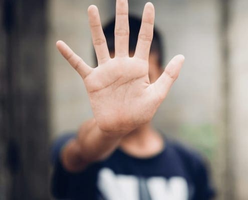 Is Shame Really Courage In Disguise - Man holding hand up to block view for privacy. Counselling Services Melbourne