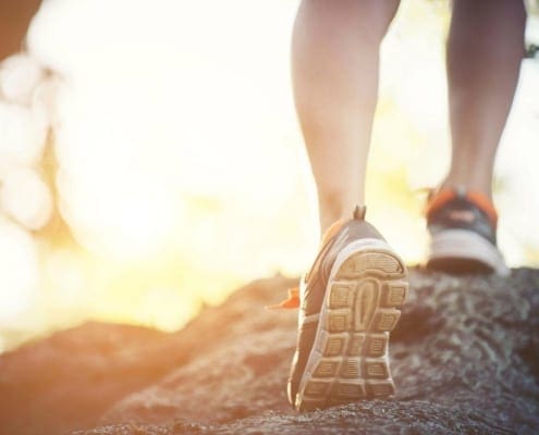 Mental Health Exercise - Person Jogging, Blurred Background, Showing Sneakers.