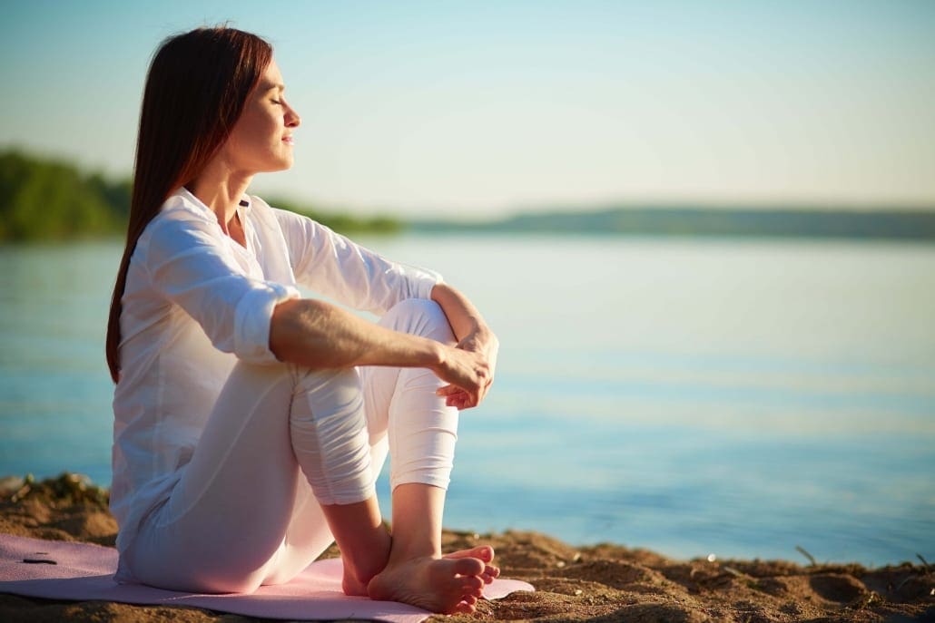 Tone The Vagus Nerve Tone The Vagus Nerve - Woman Sitting Meditating On Sand at the shore of the lake.