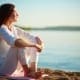 Tone The Vagus Nerve - Woman Sitting Meditating On Sand at the shore of the lake.